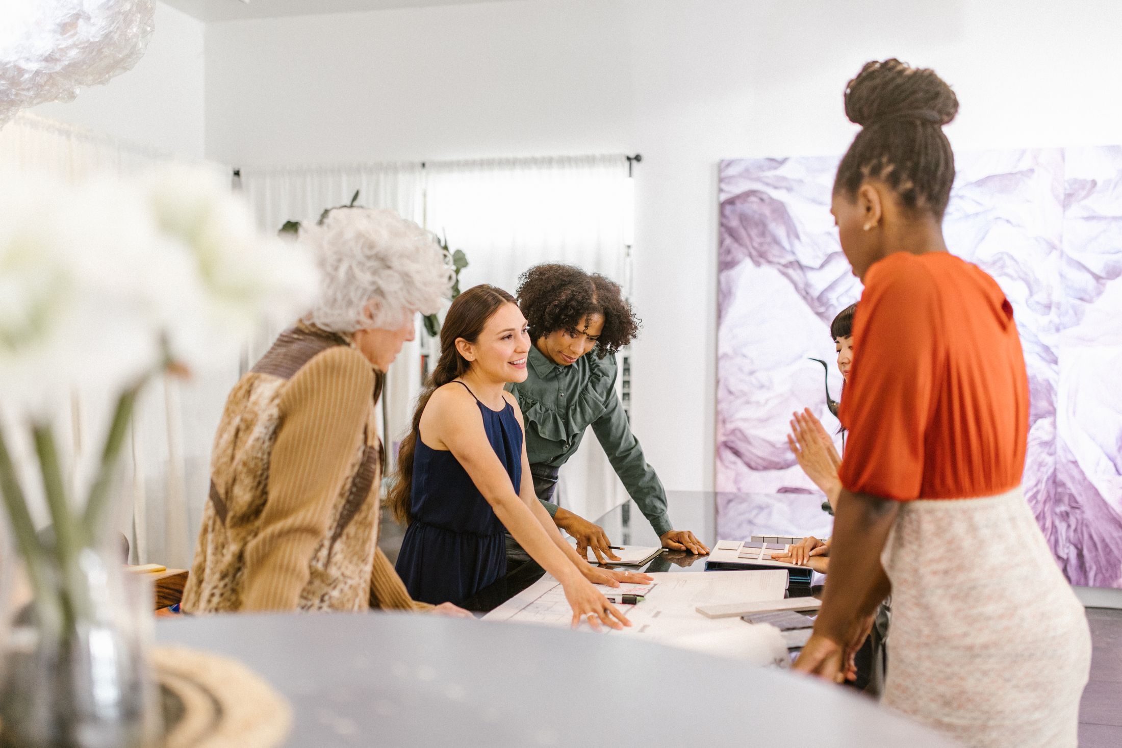 A group of professional women sharing ideas in a bright contemporary workspace